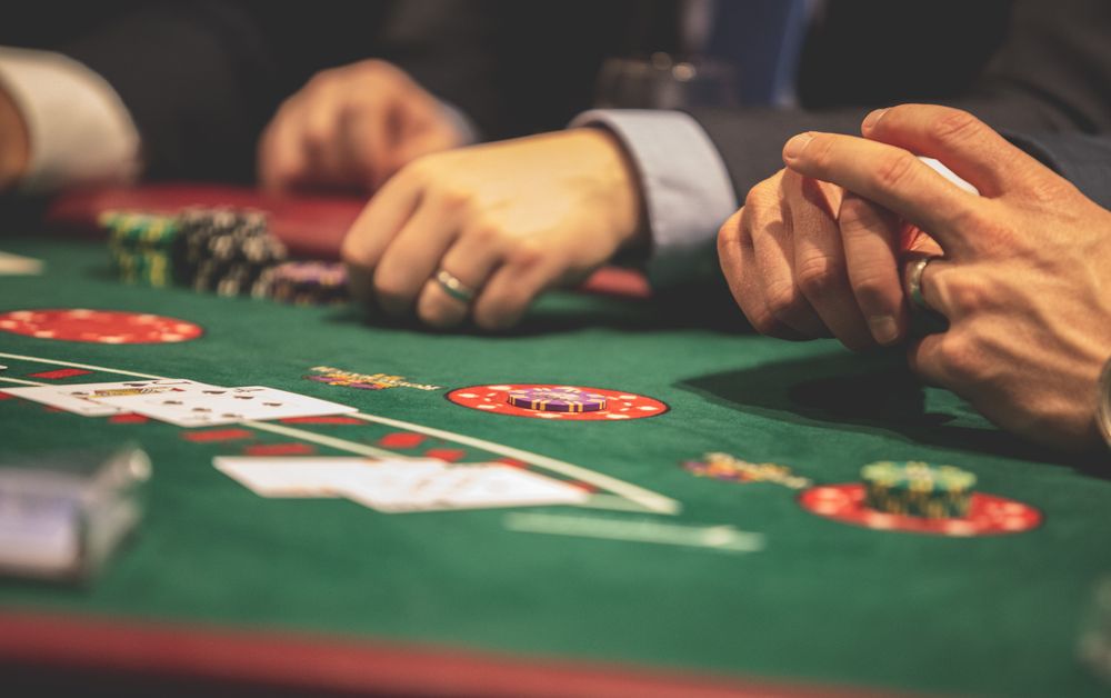 Tangan pemain memegang kartu blackjack di meja kasino