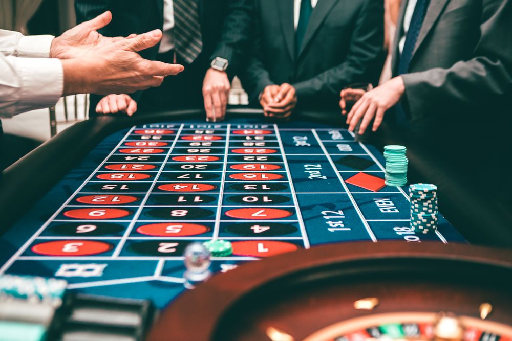 Sekelompok pemain menonton putaran roulette di meja kasino